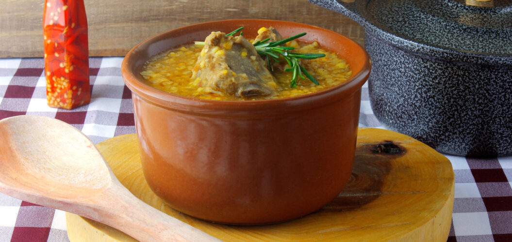 quirera de milho cremosa com pedaços dourados de carne de porco.
